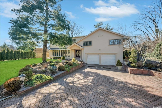 view of front of home featuring a sunroom, a front yard, and a garage