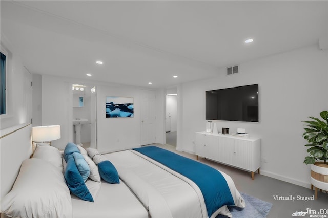 bedroom with ensuite bathroom and concrete flooring