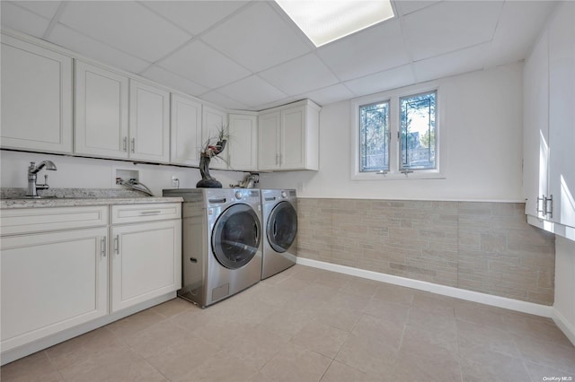 laundry room featuring washer and dryer, sink, light tile patterned flooring, and cabinets