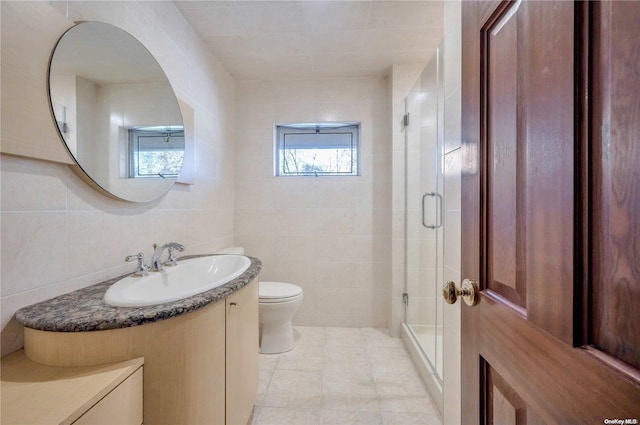 bathroom with vanity, tile patterned flooring, toilet, tile walls, and walk in shower