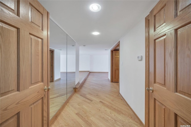 hallway with light hardwood / wood-style flooring