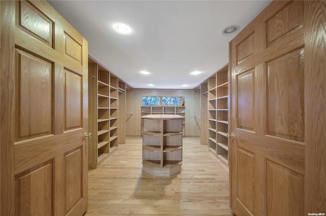 walk in closet with light hardwood / wood-style floors