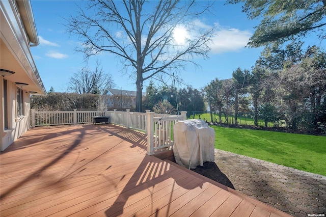 wooden terrace featuring a lawn