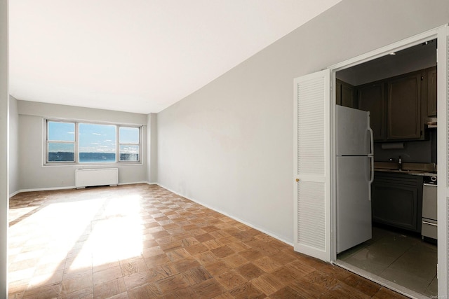 interior space featuring radiator, sink, and light parquet floors