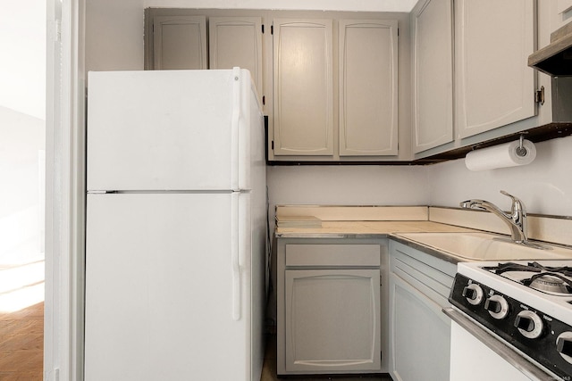 kitchen with gray cabinets, sink, and white appliances