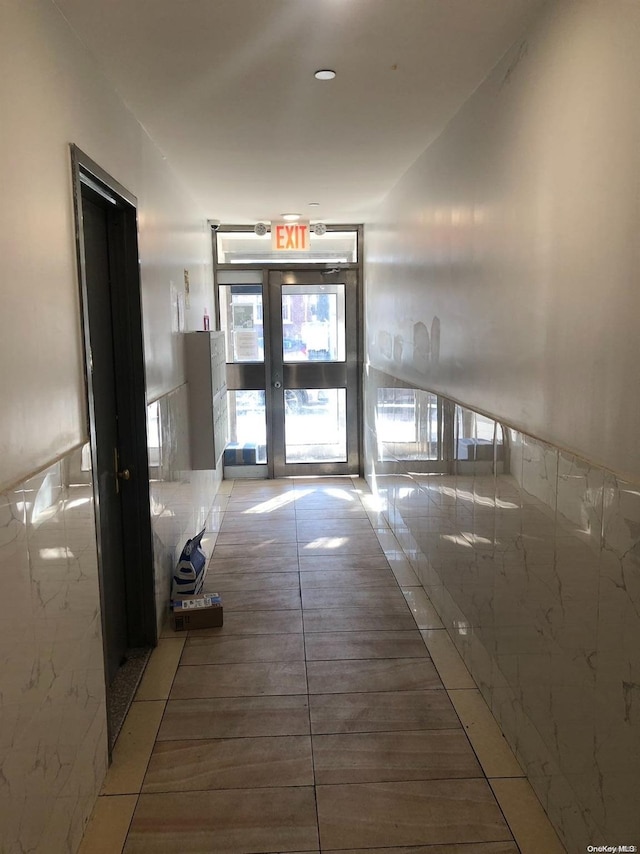 interior space featuring french doors, tile walls, and tile patterned flooring