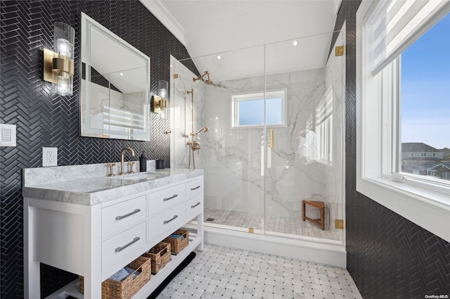 bathroom with vanity, tile walls, plenty of natural light, and a shower with door