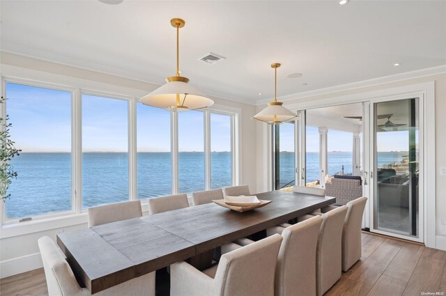 sunroom featuring a water view