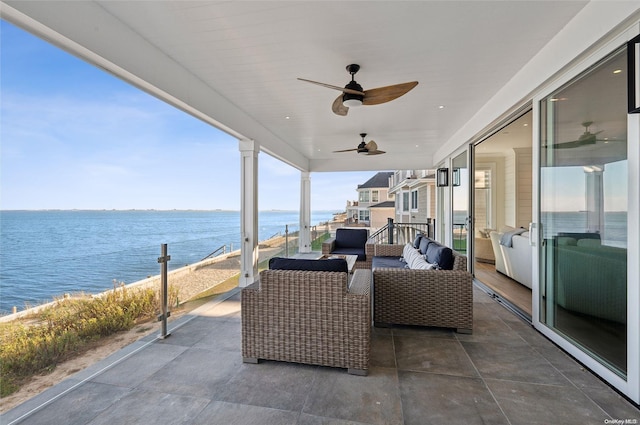 view of patio with a water view, ceiling fan, and a balcony