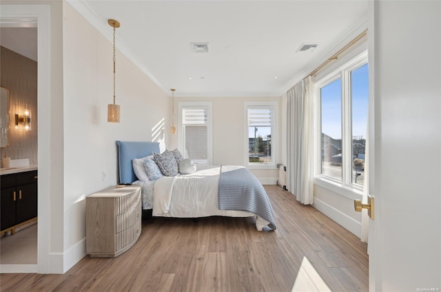 bedroom featuring ornamental molding and light hardwood / wood-style flooring