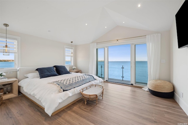 bedroom featuring vaulted ceiling, access to outside, a water view, and light wood-type flooring