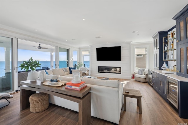 living room featuring ceiling fan, dark hardwood / wood-style floors, wine cooler, a fireplace, and sink