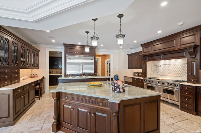 kitchen featuring tasteful backsplash, ornamental molding, a large island with sink, decorative light fixtures, and high quality appliances