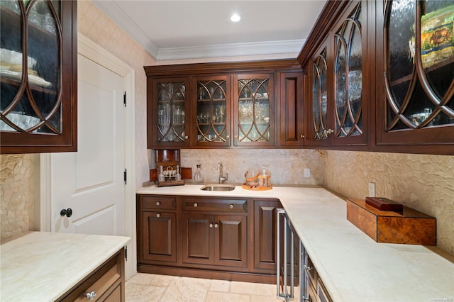 bar featuring dark brown cabinetry, ornamental molding, and sink