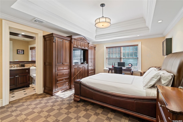 bedroom featuring crown molding, connected bathroom, and a tray ceiling