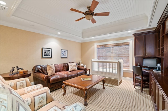 living room featuring a raised ceiling, ceiling fan, and ornamental molding