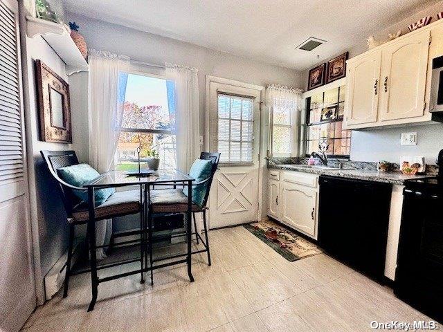 kitchen featuring white cabinets, sink, and black appliances