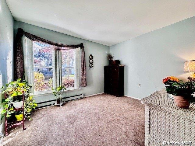 living area with baseboard heating and carpet