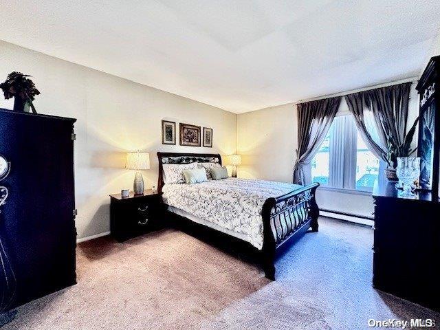 bedroom with carpet flooring and baseboard heating