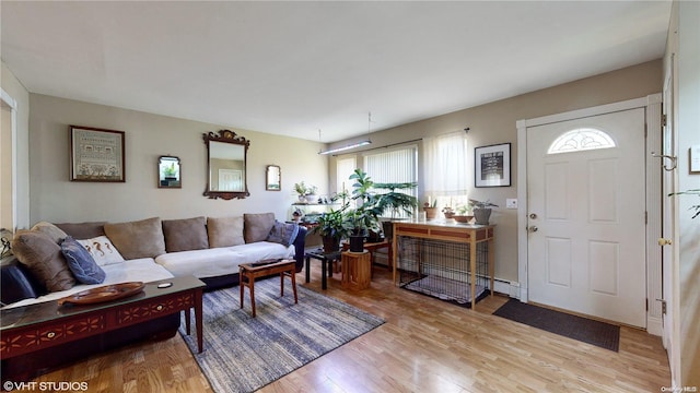 living room featuring light hardwood / wood-style floors and a baseboard heating unit