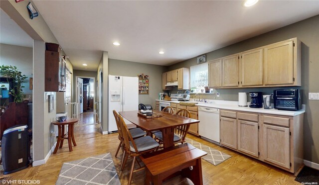 kitchen featuring light brown cabinets, white appliances, and light hardwood / wood-style flooring