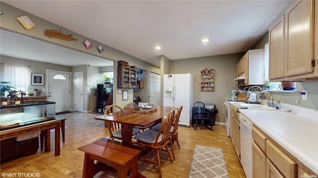 kitchen with light wood-type flooring, white appliances, and light brown cabinetry