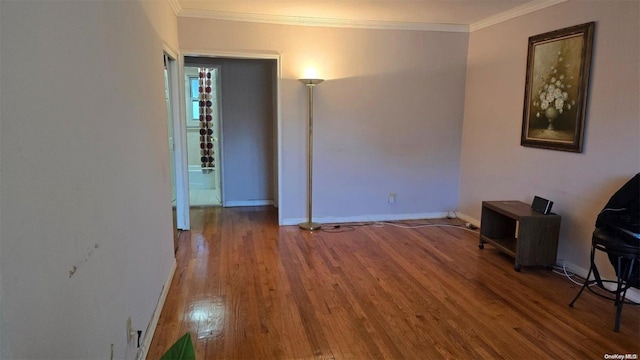 unfurnished living room featuring hardwood / wood-style flooring and crown molding