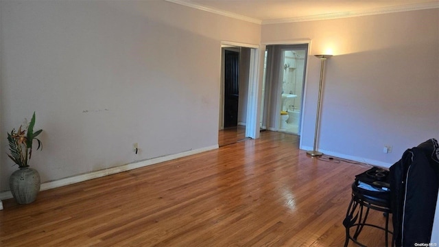 spare room featuring crown molding and hardwood / wood-style flooring