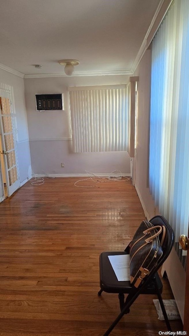 empty room featuring wood-type flooring and ornamental molding