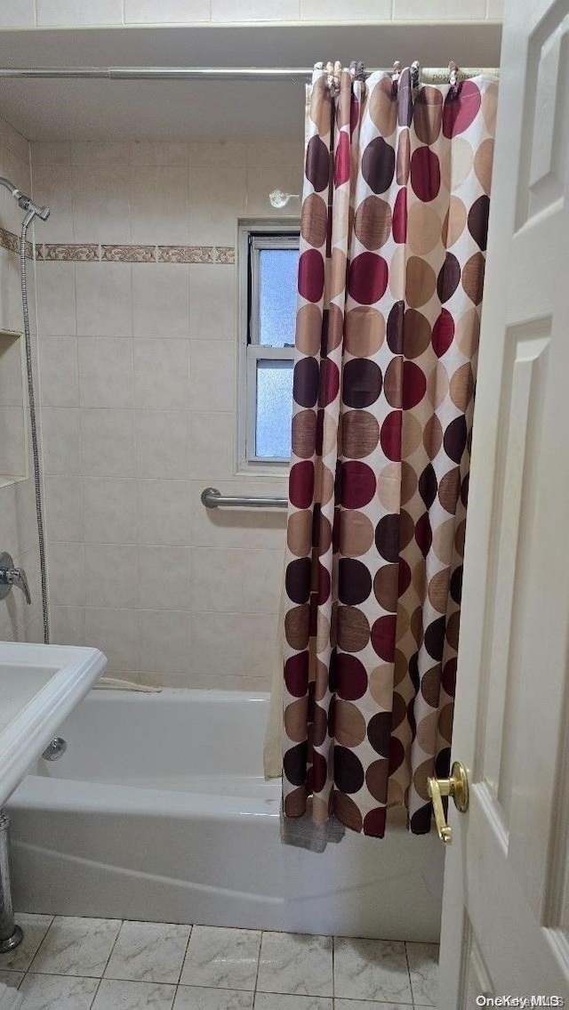 198-02 Pompeii Ave Unit 1B, Hollis, NY 11423 - bathroom featuring shower / bath combo with shower curtain and marble look tiles
