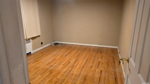 washroom with radiator heating unit and light hardwood / wood-style flooring