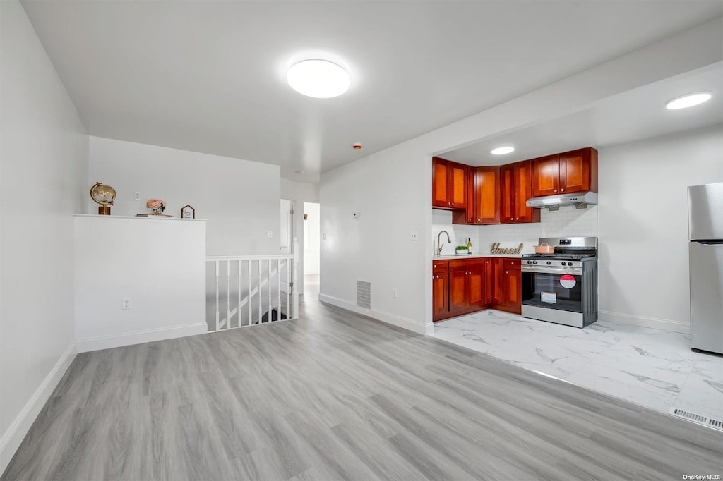 kitchen with stainless steel appliances, sink, and light hardwood / wood-style floors