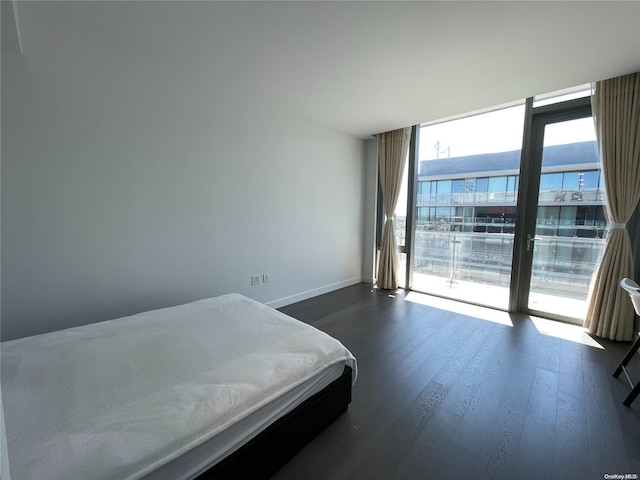 bedroom with access to exterior and dark wood-type flooring