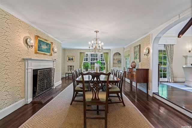 dining area featuring dark hardwood / wood-style floors, an inviting chandelier, and crown molding