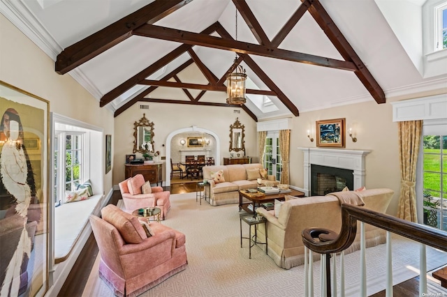 living room featuring beam ceiling, light wood-type flooring, high vaulted ceiling, and a healthy amount of sunlight