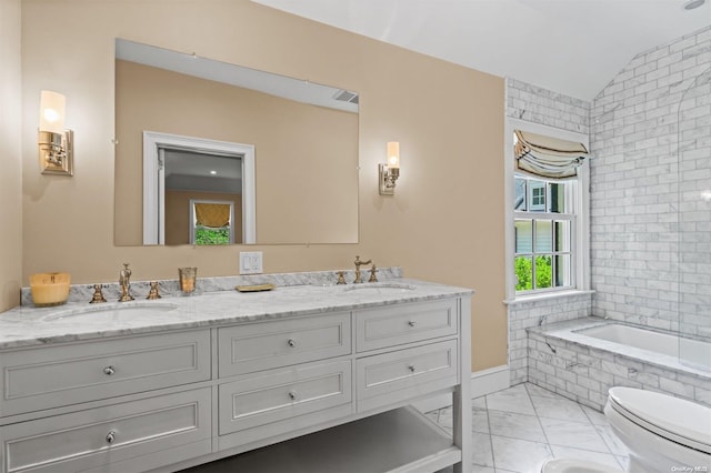 bathroom featuring toilet, vanity, vaulted ceiling, and tiled tub