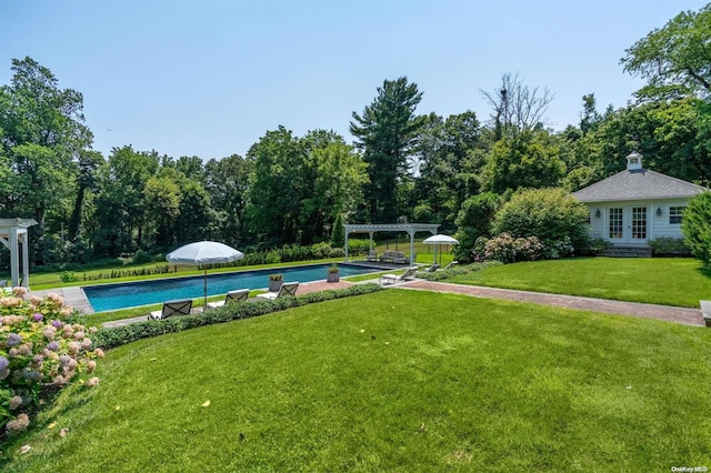 view of swimming pool with french doors and a yard