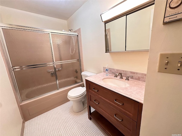 full bathroom featuring tile patterned floors, vanity, toilet, and enclosed tub / shower combo