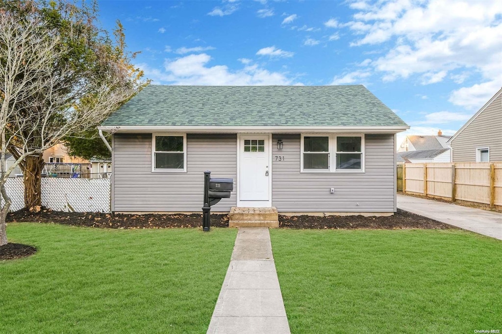 bungalow-style home with a front yard