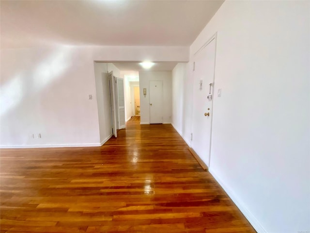 corridor with dark hardwood / wood-style flooring