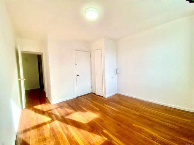 unfurnished bedroom with wood-type flooring and a closet