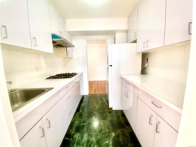 kitchen featuring sink, white cabinetry, gas stovetop, and white fridge