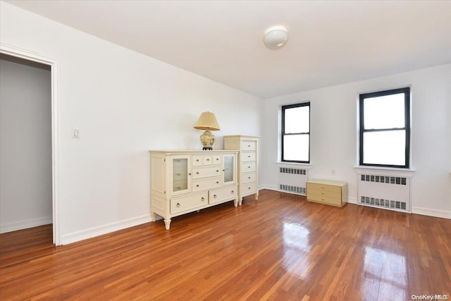 unfurnished bedroom featuring hardwood / wood-style floors and radiator