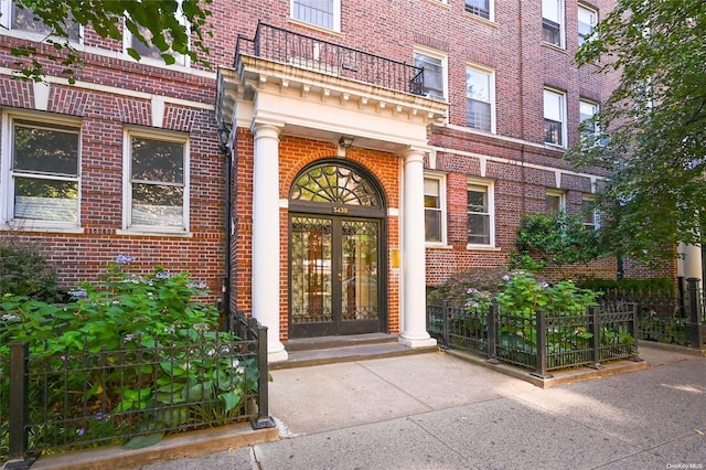 doorway to property with a balcony and french doors