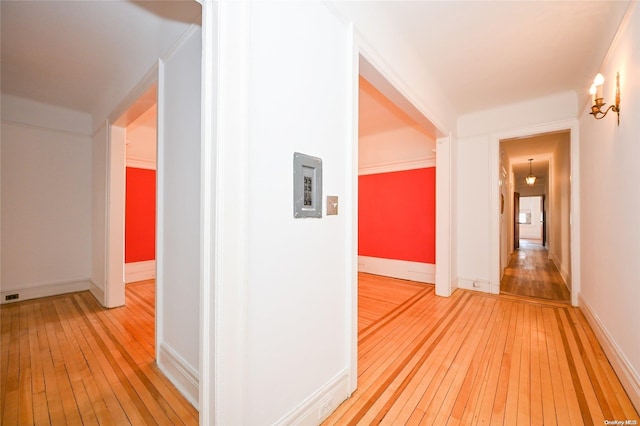 corridor with wood-type flooring and crown molding