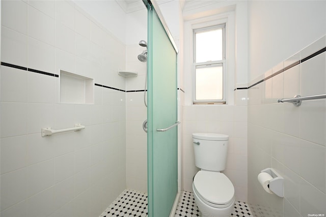 bathroom with tile patterned floors, toilet, tile walls, and walk in shower