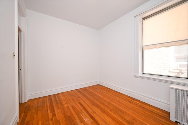 spare room with wood-type flooring and radiator heating unit