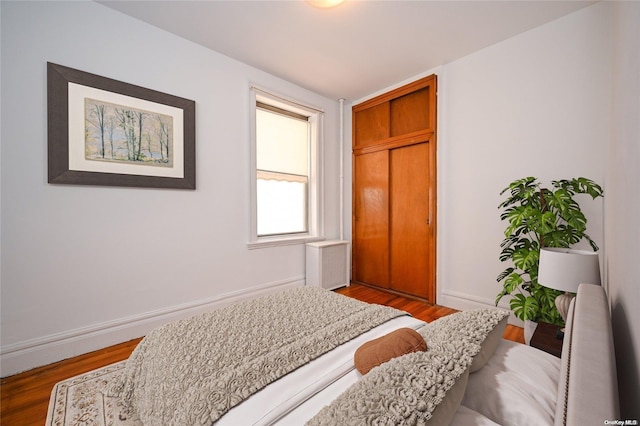 bedroom featuring wood-type flooring and radiator heating unit