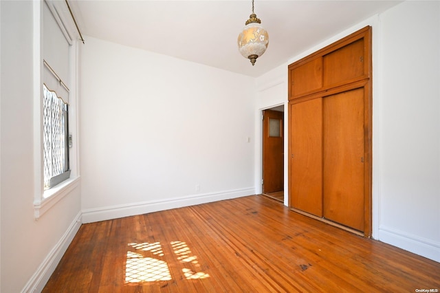 unfurnished bedroom with wood-type flooring and a closet