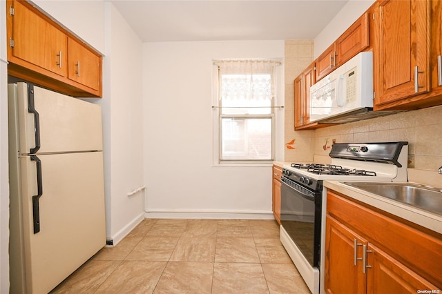 kitchen featuring light tile patterned floors, white appliances, and tasteful backsplash